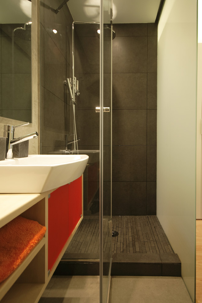 Kleines Modernes Duschbad mit verzierten Schränken, orangefarbenen Schränken, bodengleicher Dusche, Wandtoilette, grauen Fliesen, grauer Wandfarbe, Keramikboden, Aufsatzwaschbecken, Waschtisch aus Holz, grauem Boden und Falttür-Duschabtrennung in Madrid