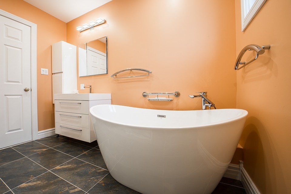 Modelo de cuarto de baño principal moderno de tamaño medio con sanitario de una pieza, baldosas y/o azulejos multicolor, parades naranjas, suelo multicolor y ducha con puerta corredera