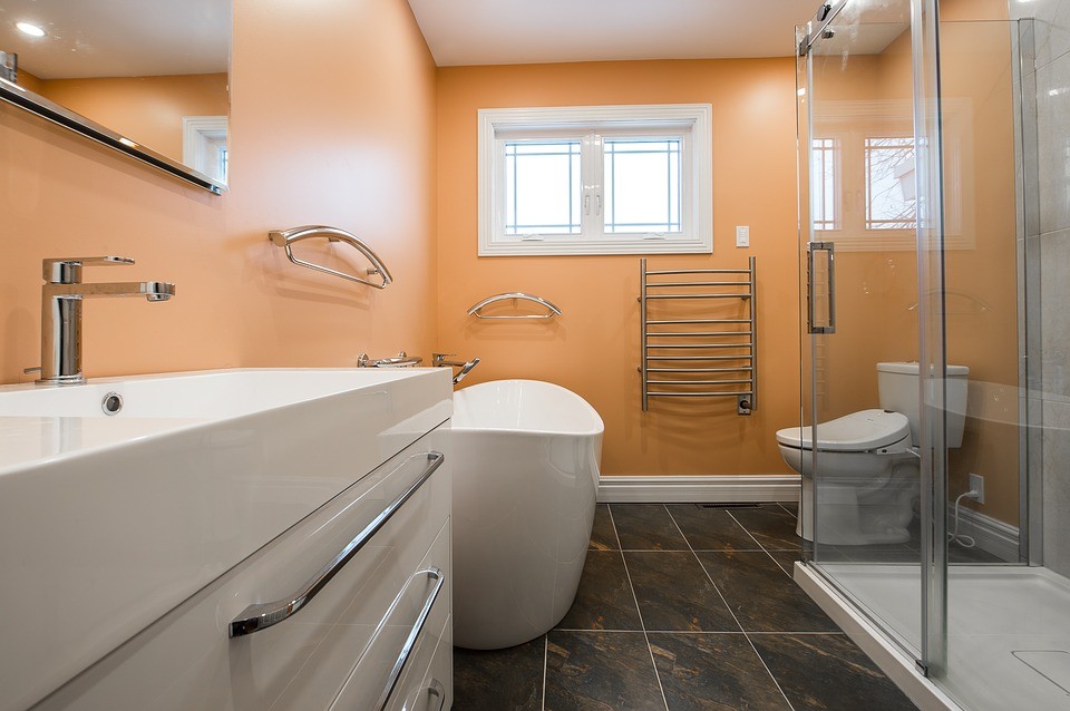 Imagen de cuarto de baño principal minimalista de tamaño medio con sanitario de una pieza, baldosas y/o azulejos multicolor, parades naranjas, suelo multicolor y ducha con puerta corredera