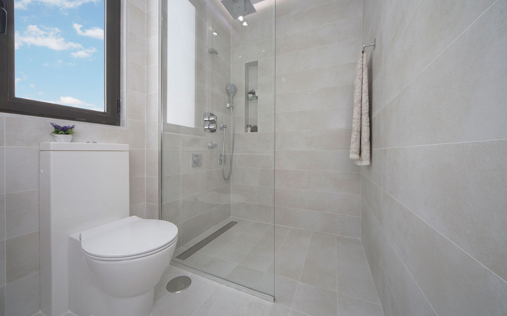 Cette photo montre une petite salle d'eau moderne avec un placard sans porte, une douche à l'italienne, un urinoir, un carrelage gris, des carreaux de céramique, un mur gris, un sol en carrelage de céramique, un sol gris et aucune cabine.