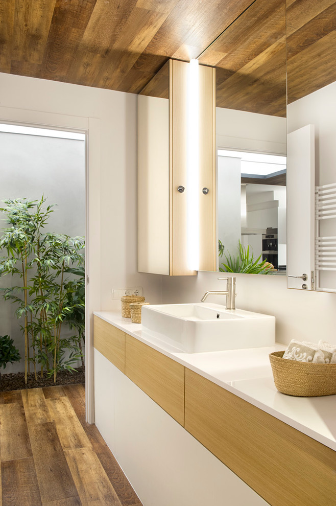 Пример оригинального дизайна: ванная комната среднего размера в современном стиле с плоскими фасадами, светлыми деревянными фасадами, белыми стенами, темным паркетным полом, настольной раковиной, душевой кабиной и зеркалом с подсветкой