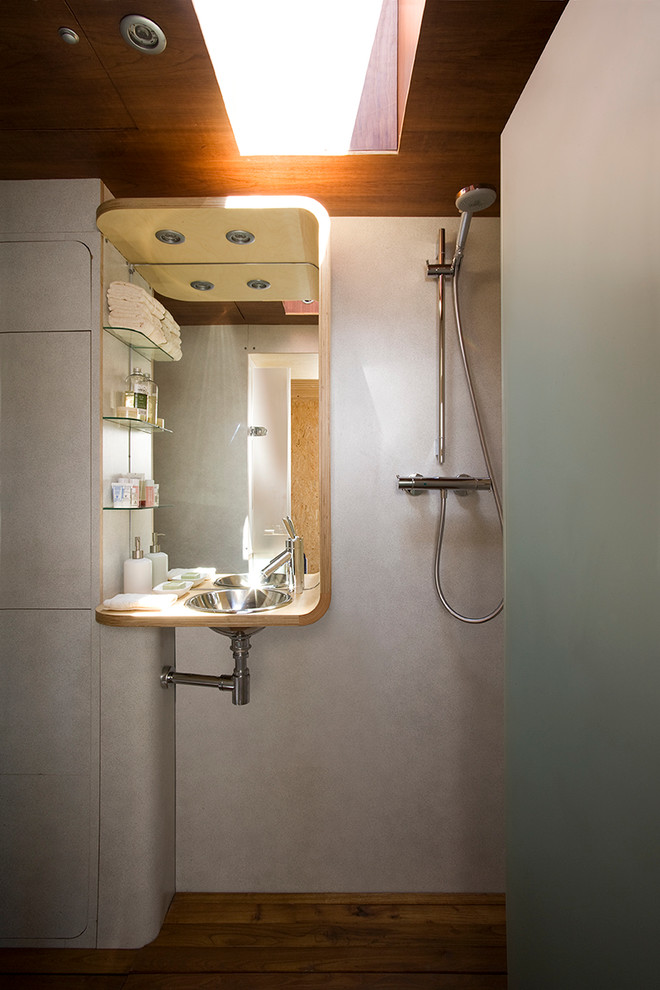 Ejemplo de cuarto de baño contemporáneo pequeño con ducha abierta, paredes grises, suelo de madera en tonos medios, aseo y ducha y lavabo bajoencimera