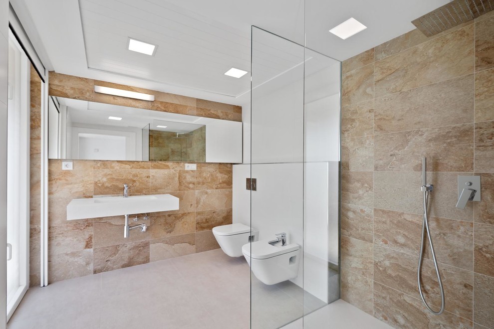 Idee per una stanza da bagno con doccia minimal con doccia a filo pavimento, bidè, piastrelle beige, pareti bianche, lavabo sospeso, pavimento bianco e doccia aperta