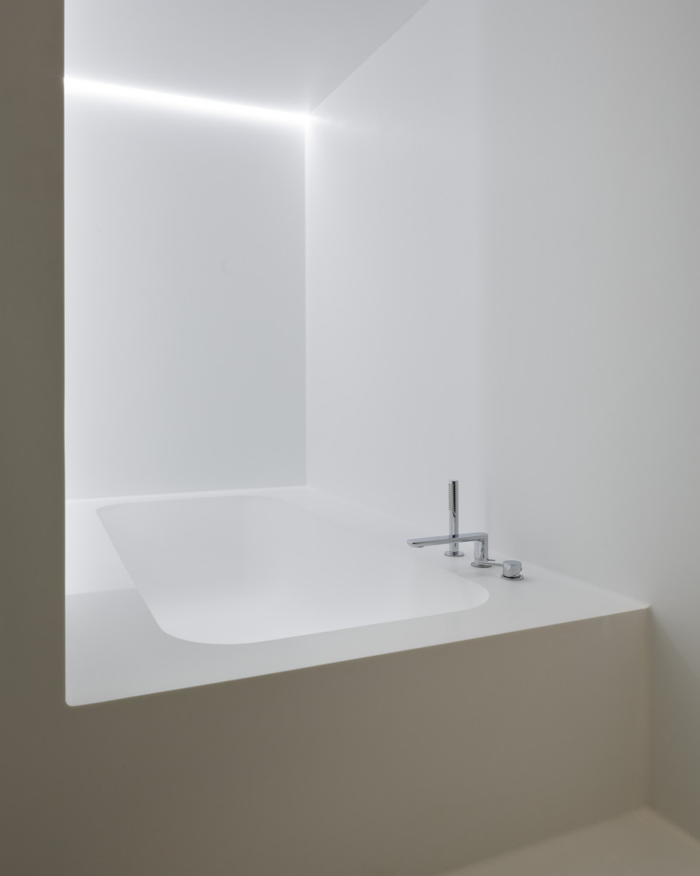 Immagine di una stanza da bagno minimal di medie dimensioni con consolle stile comò, ante bianche, vasca ad alcova, vasca/doccia, pareti bianche e pavimento bianco