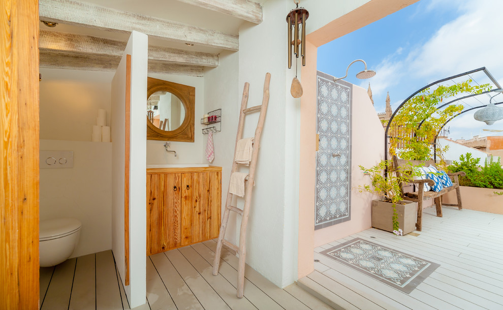 Стильный дизайн: ванная комната среднего размера в средиземноморском стиле с плоскими фасадами, фасадами цвета дерева среднего тона, инсталляцией, белыми стенами, накладной раковиной, деревянным полом и столешницей из дерева - последний тренд