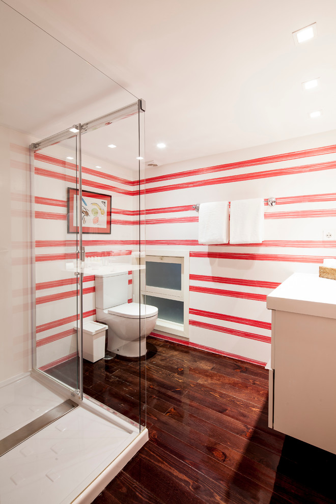 Immagine di una stanza da bagno con doccia minimal di medie dimensioni con doccia ad angolo, WC a due pezzi, piastrelle rosse, piastrelle bianche, piastrelle in ceramica, pareti rosse, parquet scuro, ante lisce, ante bianche e lavabo integrato