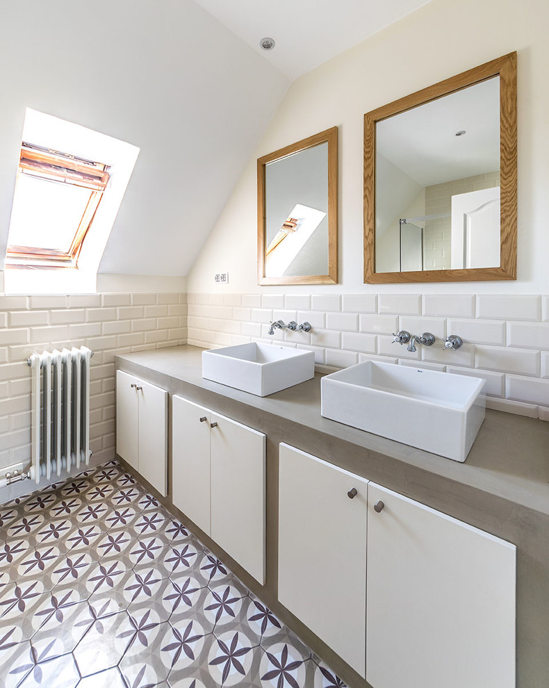 На фото: ванная комната среднего размера в скандинавском стиле с плоскими фасадами, белыми фасадами, душем в нише, белой плиткой, белыми стенами, полом из керамической плитки, душевой кабиной, настольной раковиной и столешницей из бетона с