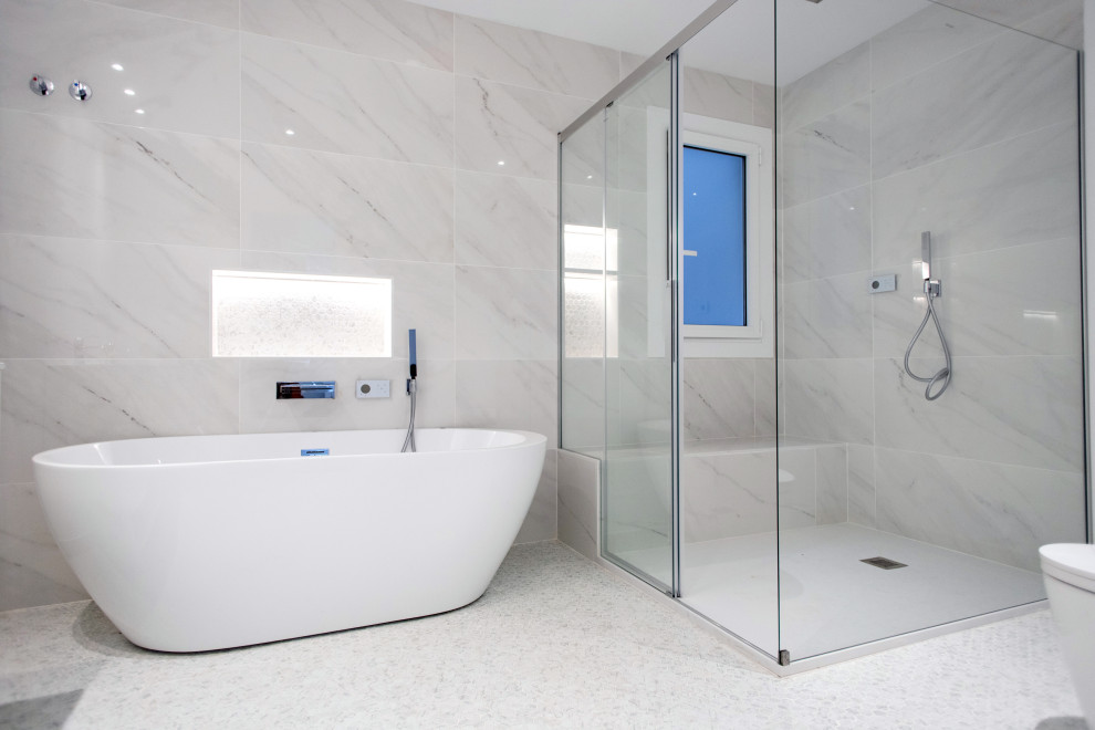 Foto di una grande stanza da bagno padronale design con vasca freestanding, doccia a filo pavimento, WC monopezzo, piastrelle beige, piastrelle in ceramica, pavimento alla veneziana, pavimento bianco, porta doccia scorrevole, top bianco, panca da doccia, due lavabi e mobile bagno incassato