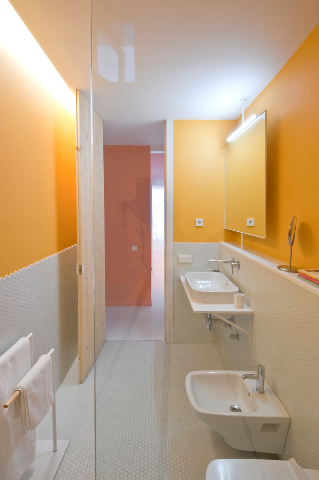 Modelo de cuarto de baño contemporáneo de tamaño medio con ducha a ras de suelo, bidé, parades naranjas, aseo y ducha y lavabo suspendido