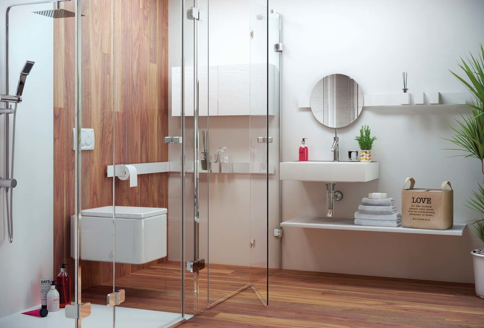 Modelo de cuarto de baño actual de tamaño medio con armarios abiertos, ducha esquinera, sanitario de pared, paredes blancas, suelo de madera oscura, aseo y ducha y lavabo suspendido