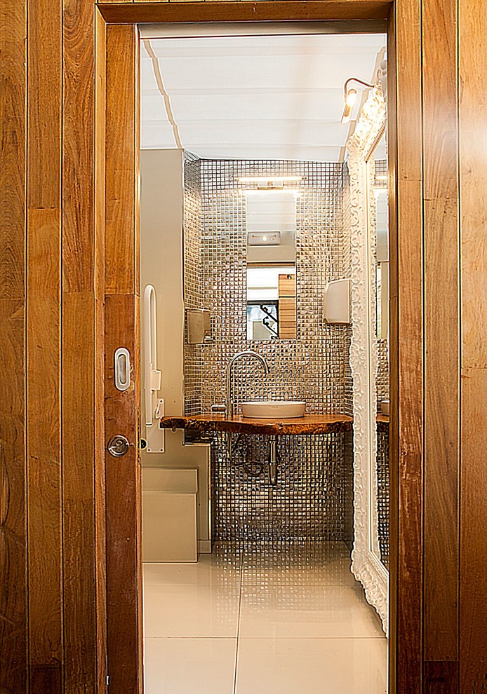 Идея дизайна: маленькая главная ванная комната в стиле модернизм с писсуаром, белой плиткой, керамогранитной плиткой, белыми стенами, полом из керамогранита, настольной раковиной, столешницей из дерева и белым полом для на участке и в саду