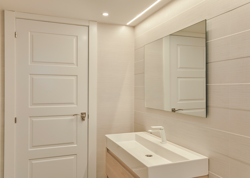 Modern inredning av ett litet vit vitt badrum med dusch, med öppna hyllor, vita skåp, en kantlös dusch, ett urinoar, beige kakel, keramikplattor, beige väggar, klinkergolv i porslin, ett konsol handfat, bänkskiva i kvartsit, grått golv och med dusch som är öppen