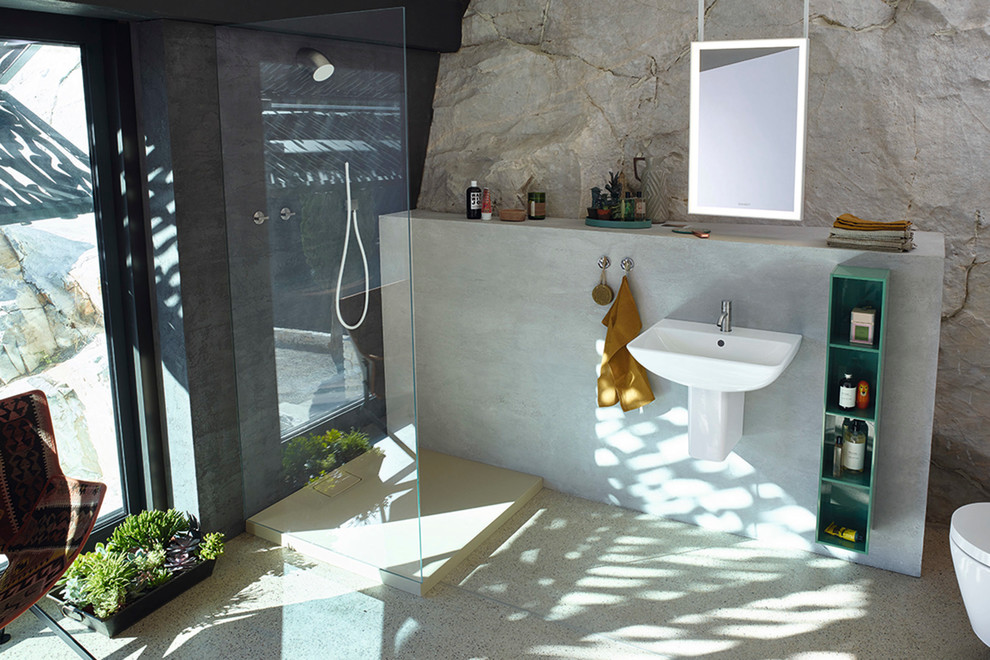 Réalisation d'une salle de bain marine de taille moyenne avec une douche ouverte, WC suspendus, un mur gris et un lavabo suspendu.