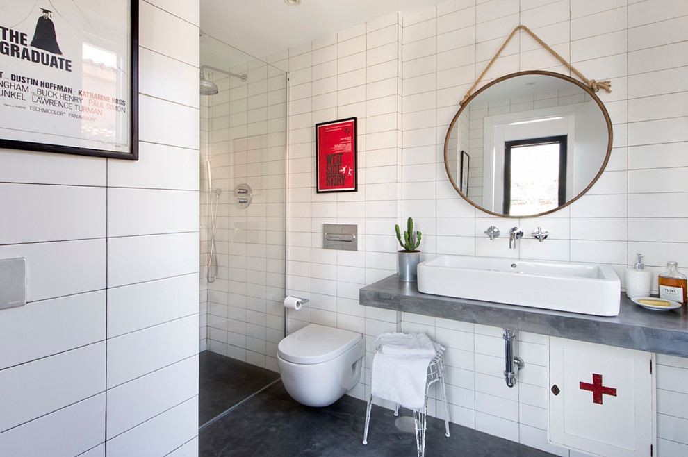 Ejemplo de cuarto de baño principal moderno de tamaño medio con ducha empotrada, sanitario de pared, baldosas y/o azulejos blancos, paredes blancas, lavabo sobreencimera, encimera de cemento y microcemento