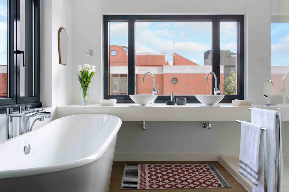 Aménagement d'une douche en alcôve principale contemporaine de taille moyenne avec une baignoire indépendante, un carrelage blanc, un mur blanc, un sol en bois brun, une vasque et un plan de toilette en béton.