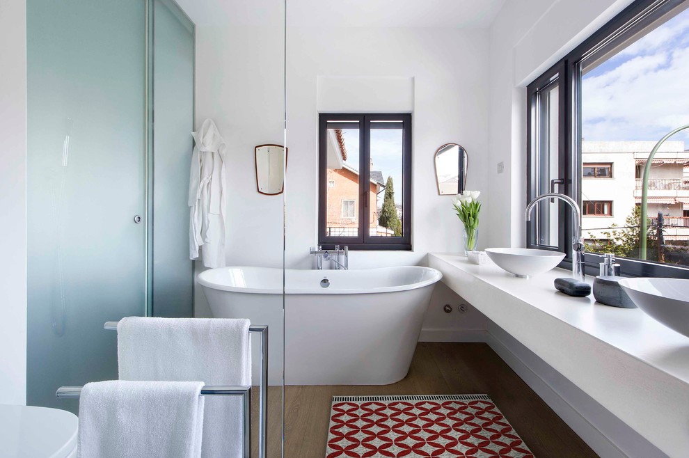 Inredning av ett modernt mellanstort en-suite badrum, med ett fristående badkar, en dusch/badkar-kombination, vita väggar, mellanmörkt trägolv och ett fristående handfat