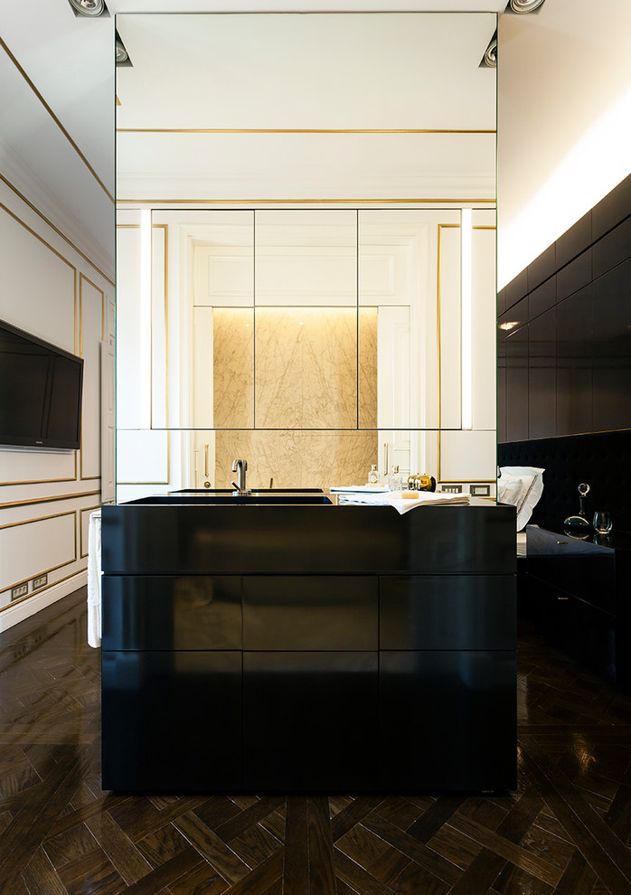 Cette image montre une grande salle de bain principale traditionnelle avec un placard à porte plane, des portes de placard noires, un mur blanc, parquet foncé et un lavabo intégré.