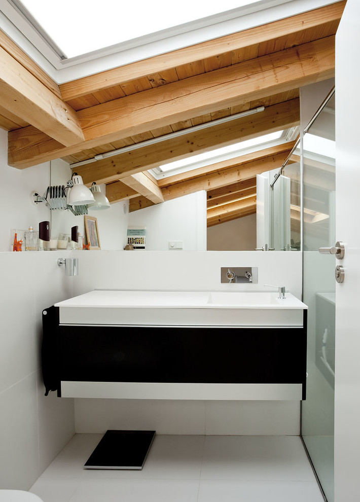 Modelo de cuarto de baño escandinavo pequeño con armarios con paneles lisos, puertas de armario negras, ducha esquinera, paredes blancas, suelo de baldosas de cerámica, aseo y ducha y lavabo de seno grande