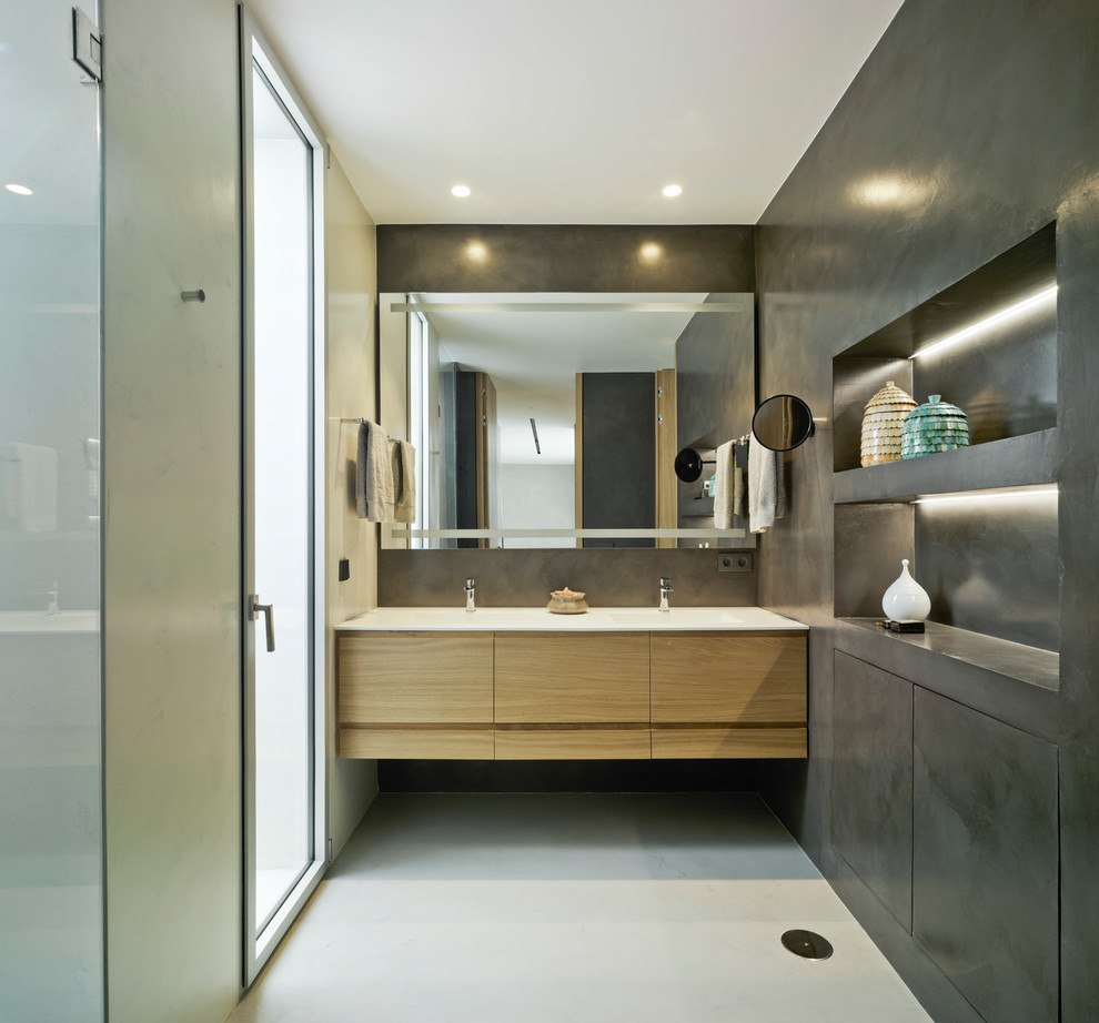 Пример оригинального дизайна: ванная комната среднего размера в стиле модернизм с черными стенами, бетонным полом, монолитной раковиной, серым полом, плоскими фасадами, фасадами цвета дерева среднего тона и зеркалом с подсветкой