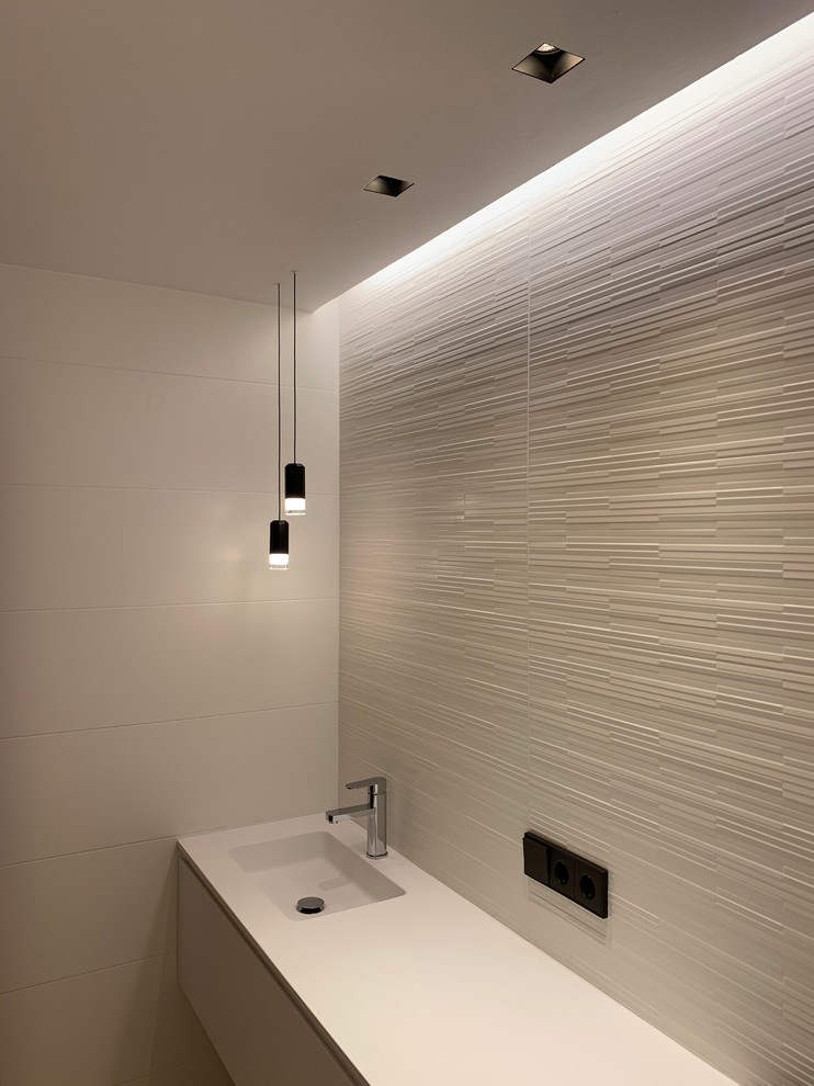 Cette image montre une salle d'eau minimaliste de taille moyenne avec une douche à l'italienne, un mur blanc et un sol blanc.