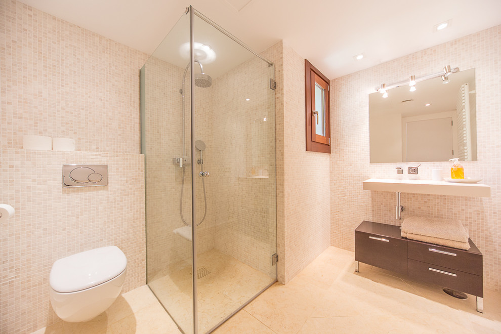 Inspiration för mellanstora medelhavsstil badrum med dusch, med möbel-liknande, skåp i mörkt trä, en hörndusch, en vägghängd toalettstol, beige väggar och ett väggmonterat handfat