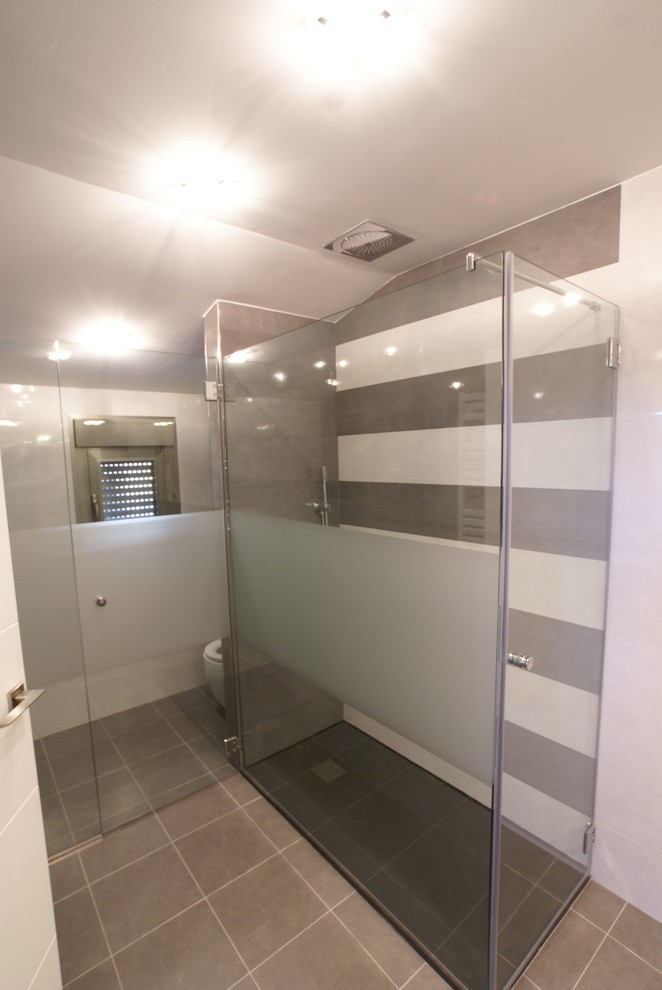 Ejemplo de cuarto de baño moderno de tamaño medio con ducha a ras de suelo, sanitario de dos piezas y aseo y ducha