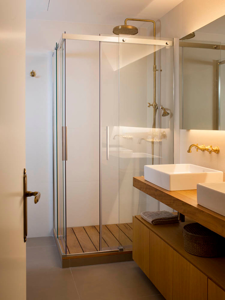 Esempio di una stanza da bagno con doccia scandinava di medie dimensioni con ante lisce, ante in legno scuro, doccia ad angolo, pareti bianche, pavimento con piastrelle in ceramica, lavabo a bacinella e top in legno