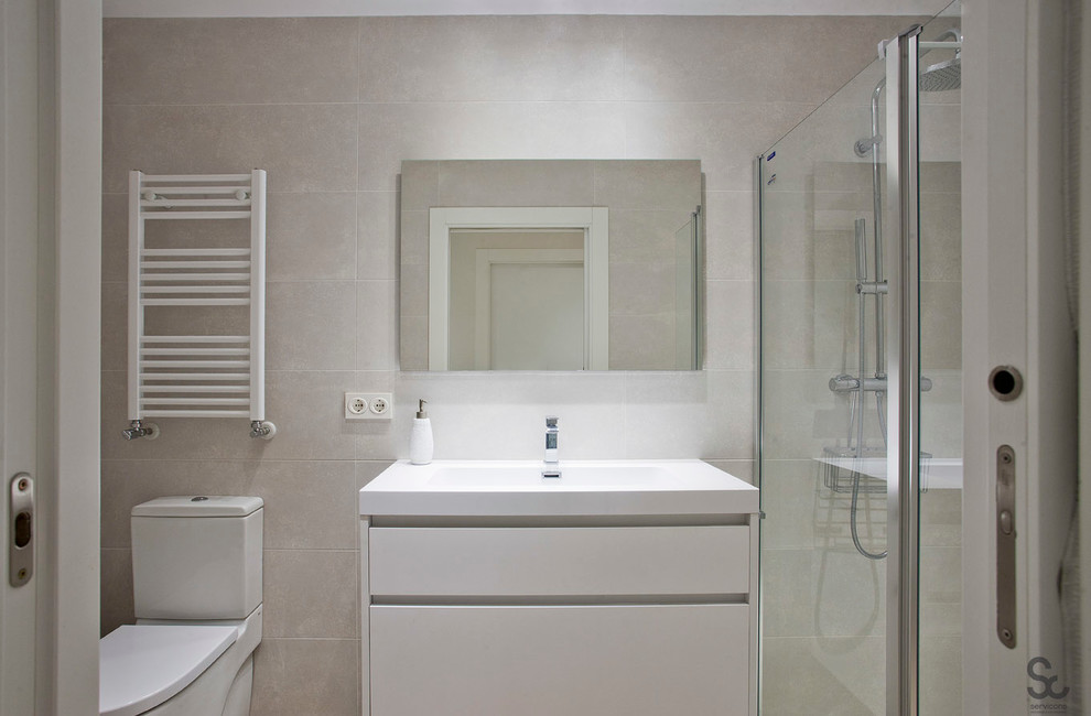 Minimalistisk inredning av ett mellanstort badrum med dusch, med släta luckor, vita skåp, en dusch i en alkov, en toalettstol med separat cisternkåpa, grå väggar och ett integrerad handfat