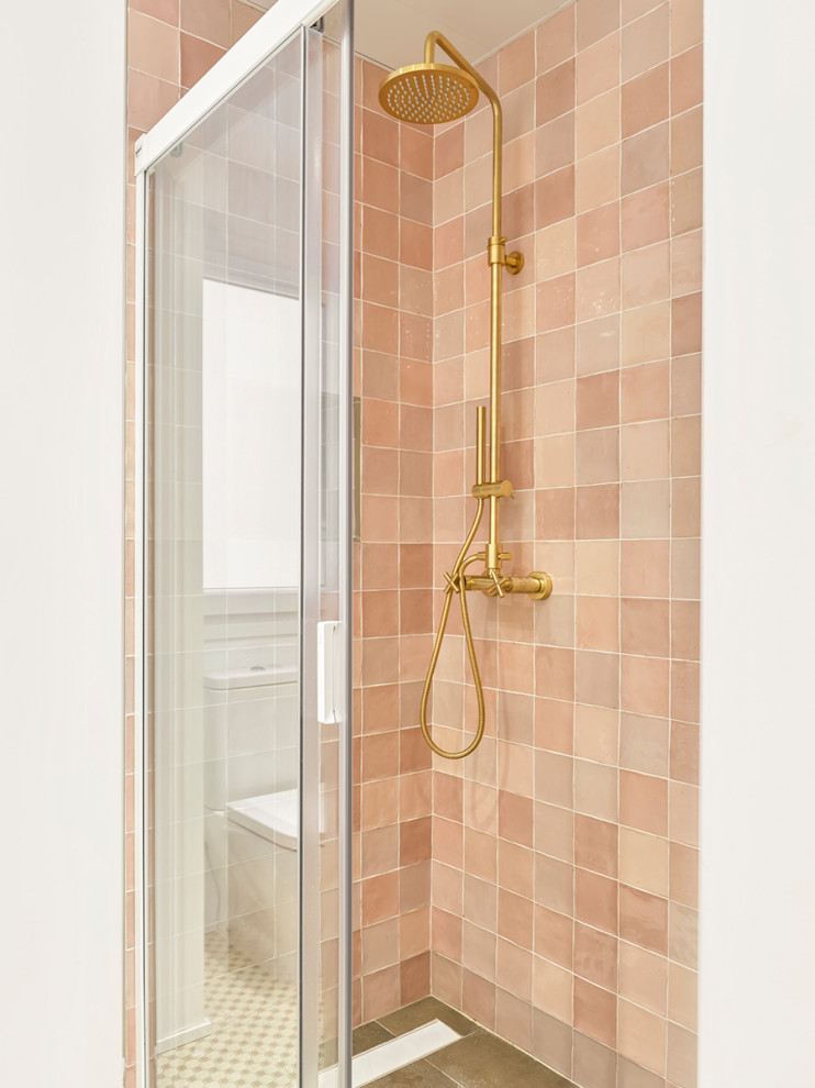 Inredning av ett minimalistiskt litet vit vitt en-suite badrum, med öppna hyllor, vita skåp, en kantlös dusch, rosa kakel, keramikplattor, flerfärgade väggar, klinkergolv i porslin, ett konsol handfat, kaklad bänkskiva, grått golv och dusch med skjutdörr