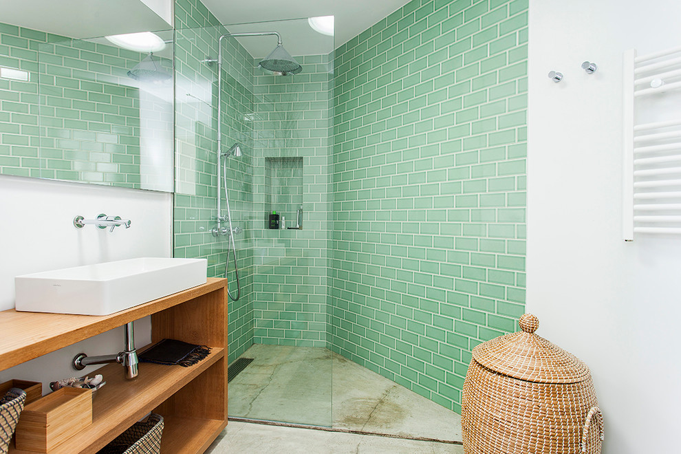 Modernes Badezimmer mit offenen Schränken, hellbraunen Holzschränken, Eckdusche, grünen Fliesen, weißer Wandfarbe, Betonboden, Aufsatzwaschbecken, Waschtisch aus Holz, grauem Boden, offener Dusche und beiger Waschtischplatte in Barcelona