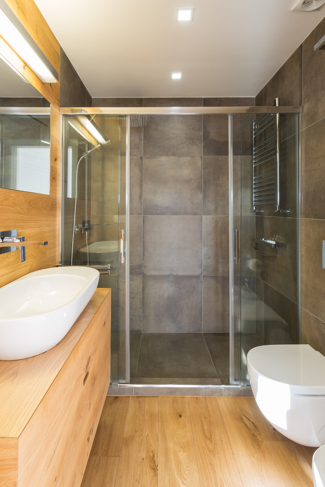 Idee per una stanza da bagno con doccia nordica di medie dimensioni con ante lisce, ante in legno scuro, doccia alcova, WC sospeso, pavimento in legno massello medio, lavabo a bacinella e top in legno