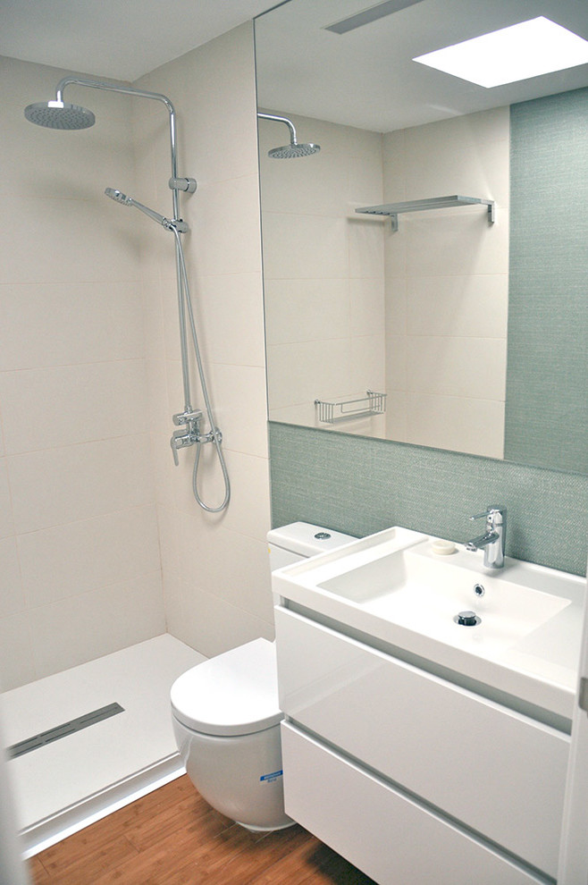 Idéer för små funkis en-suite badrum, med släta luckor, vita skåp, bambugolv, ett väggmonterat handfat, bänkskiva i akrylsten och dusch med skjutdörr