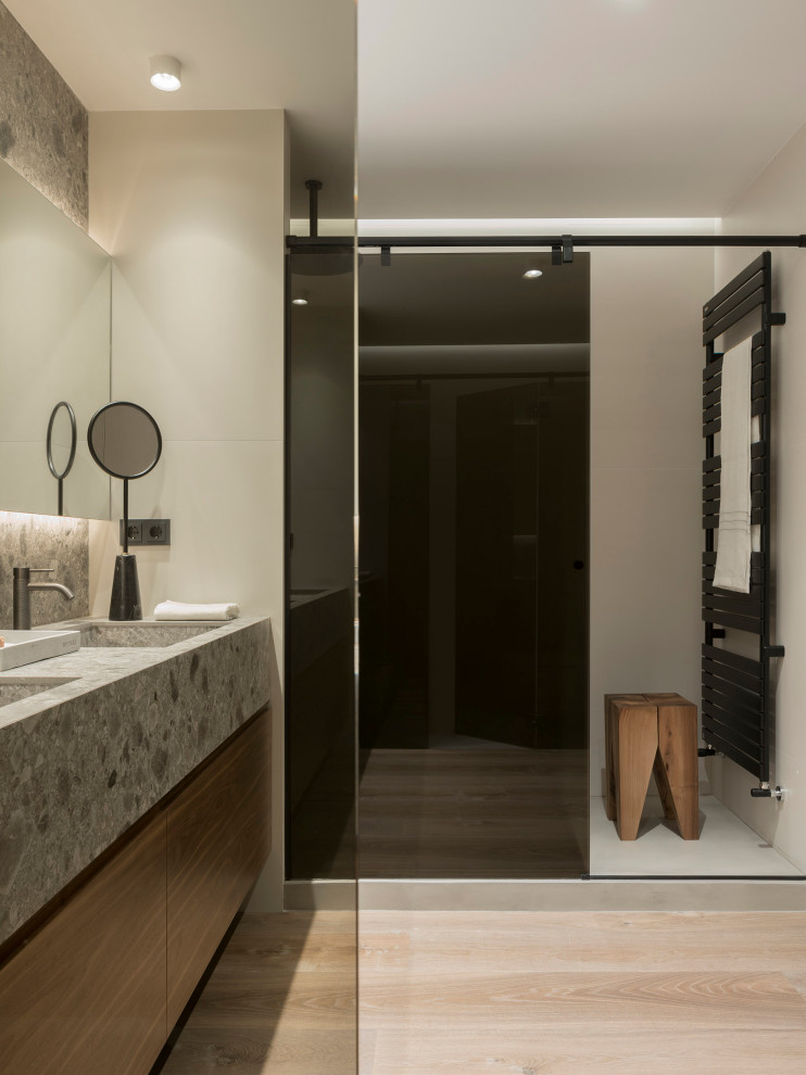 Cette photo montre une grande salle de bain principale tendance avec un placard en trompe-l'oeil, des portes de placard grises, un mur beige, parquet foncé, un sol marron et un plan de toilette gris.