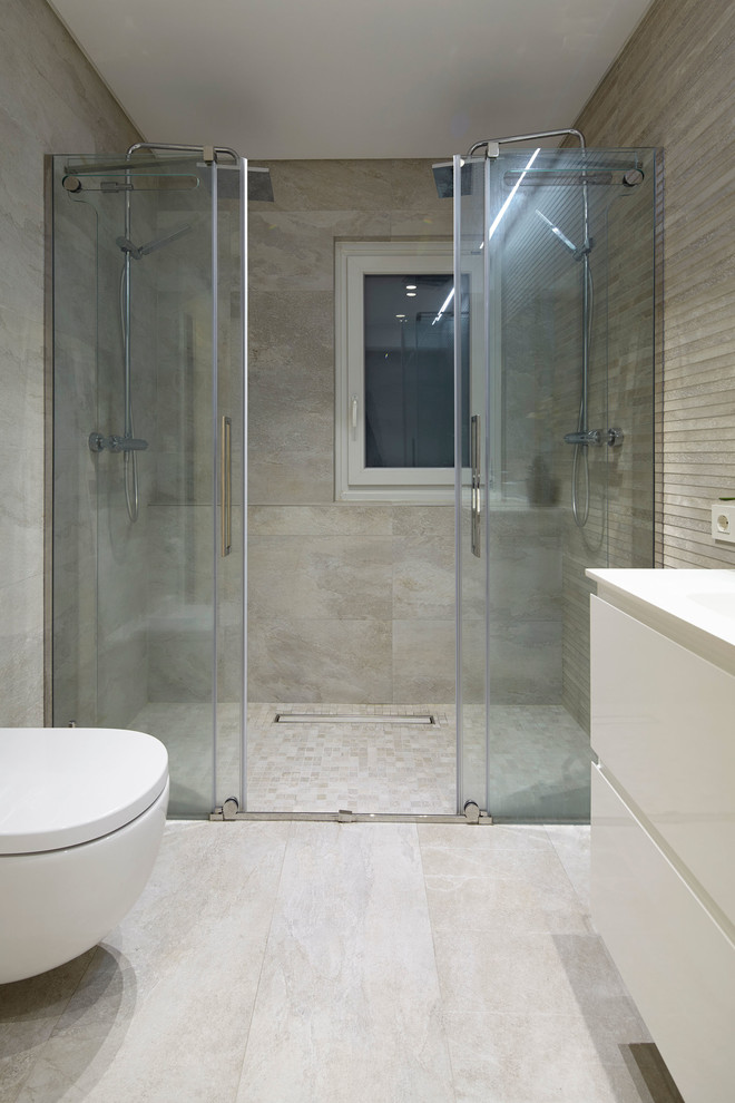 Modelo de cuarto de baño escandinavo de tamaño medio con armarios con paneles lisos, puertas de armario blancas, ducha doble, sanitario de pared, paredes beige, aseo y ducha y lavabo integrado