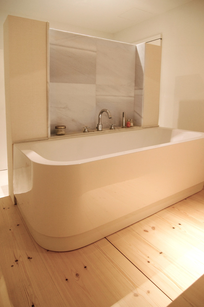 Modelo de cuarto de baño principal contemporáneo de tamaño medio con bañera empotrada, paredes blancas y suelo de madera clara