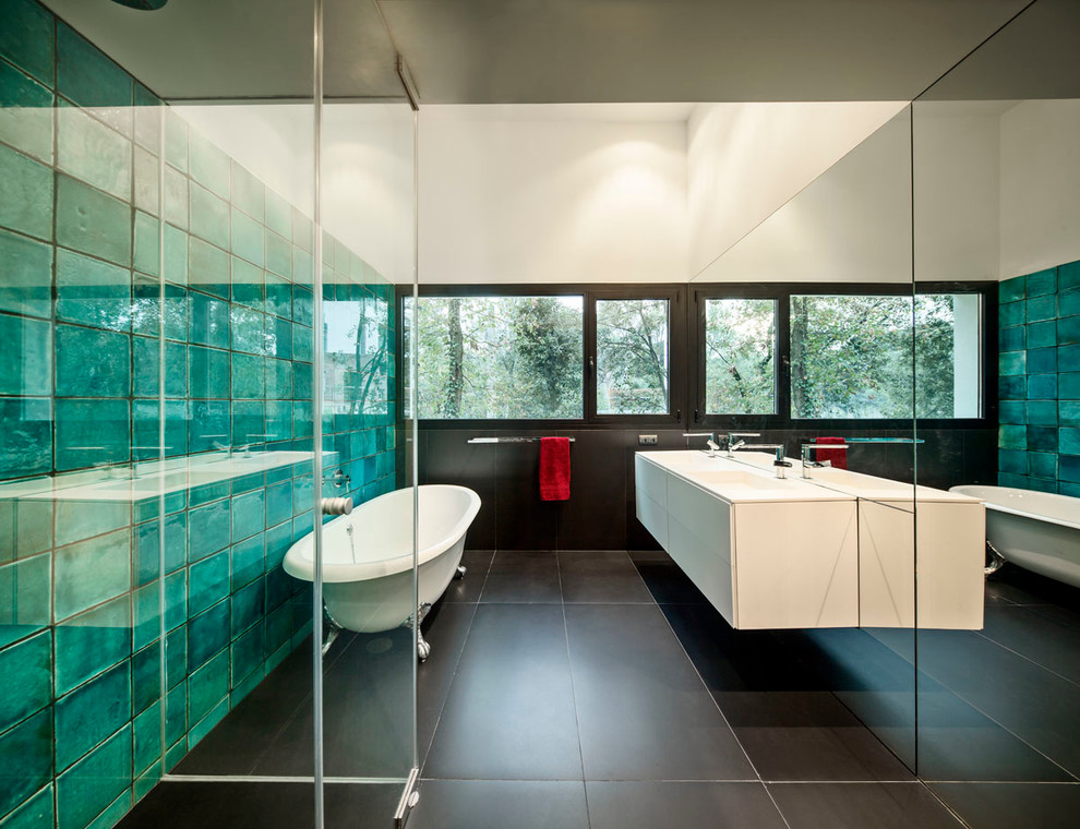 Inredning av ett modernt mellanstort en-suite badrum, med släta luckor, vita skåp, ett badkar med tassar, en kantlös dusch, grön kakel, blå kakel, gröna väggar, keramikplattor, klinkergolv i keramik och bänkskiva i akrylsten