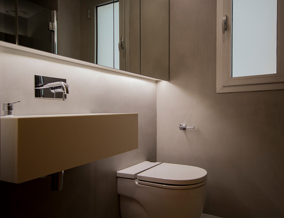 Cette photo montre une petite salle d'eau scandinave avec un mur gris, un lavabo suspendu et un sol gris.