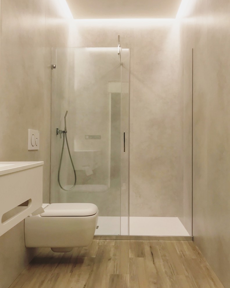Idéer för att renovera ett mellanstort funkis badrum, med släta luckor, vita skåp, en kantlös dusch, en vägghängd toalettstol, cementkakel, grå väggar, klinkergolv i porslin, ett väggmonterat handfat, bänkskiva i akrylsten och dusch med skjutdörr