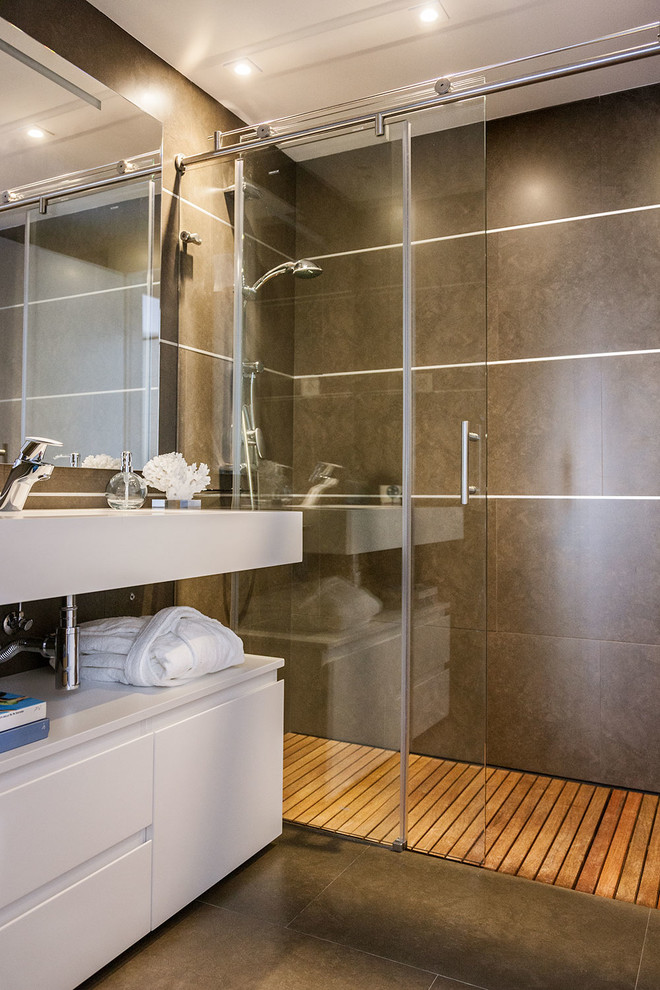 Foto di una stanza da bagno con doccia minimal di medie dimensioni con ante lisce, ante bianche, doccia alcova, pavimento con piastrelle in ceramica, lavabo integrato e pareti marroni