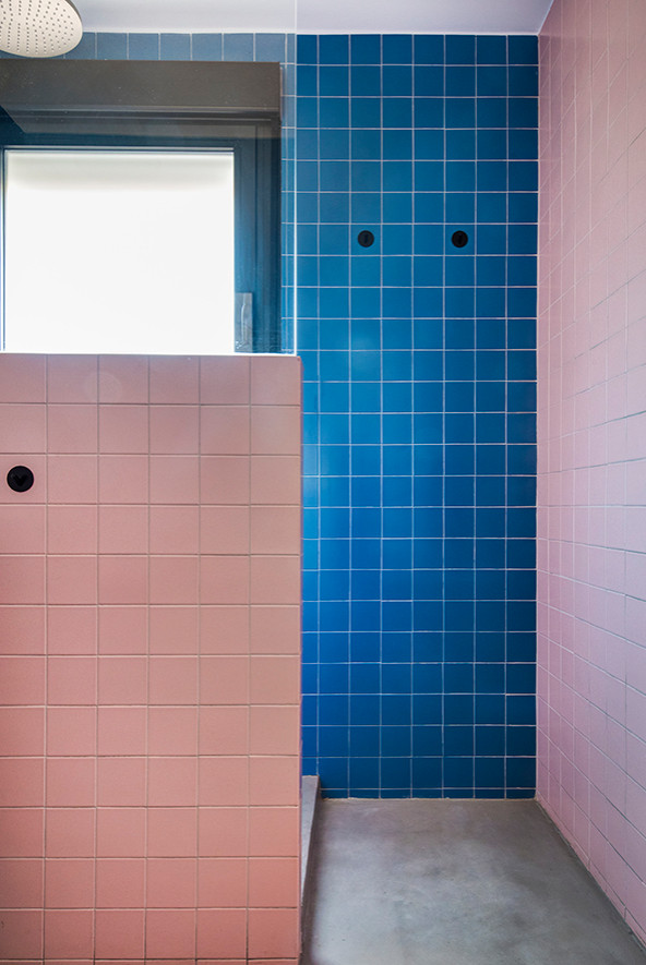 Foto de cuarto de baño actual con ducha empotrada, sanitario de pared, baldosas y/o azulejos multicolor, suelo de cemento, suelo gris y microcemento