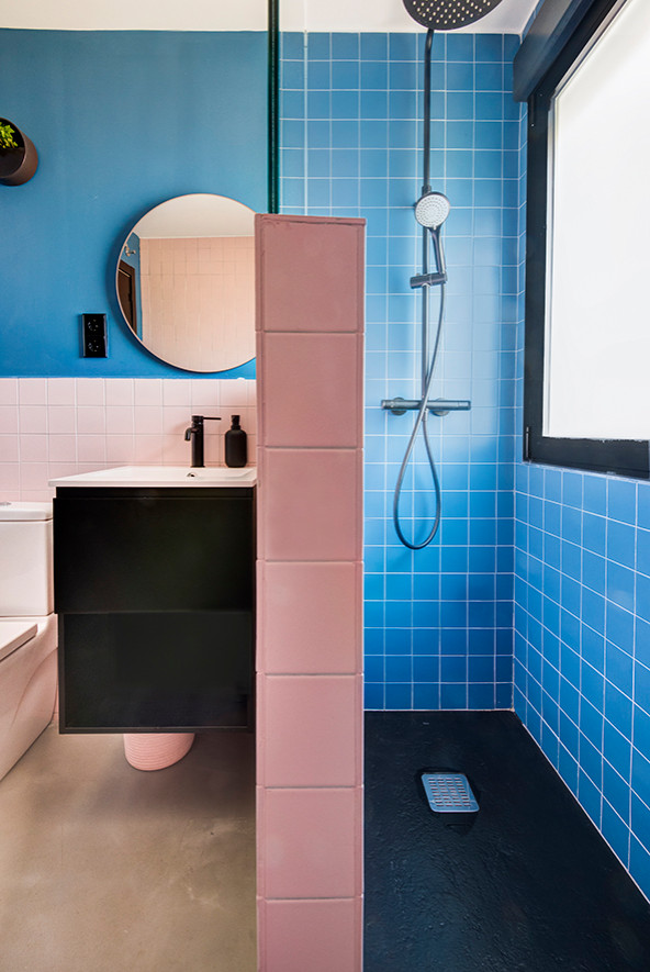 Ispirazione per una stanza da bagno nordica con doccia alcova, WC sospeso, piastrelle multicolore, pavimento in cemento e pavimento grigio