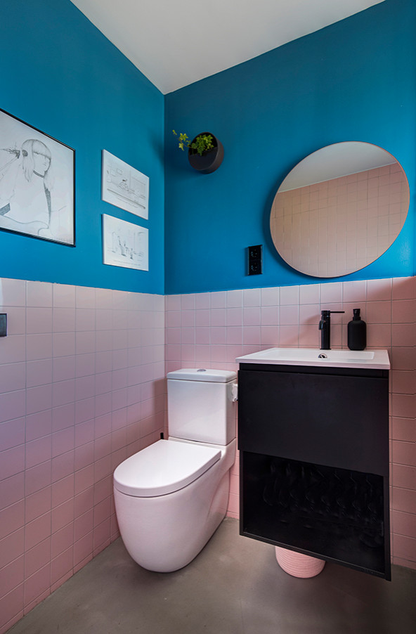 Ejemplo de aseo escandinavo con sanitario de pared, baldosas y/o azulejos multicolor, suelo de cemento y suelo gris