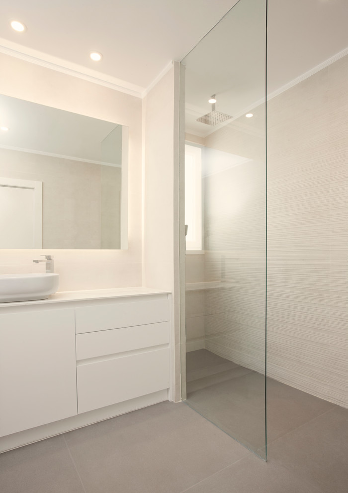 Modernes Duschbad mit flächenbündigen Schrankfronten, bodengleicher Dusche, grauem Boden und weißer Waschtischplatte in Valencia
