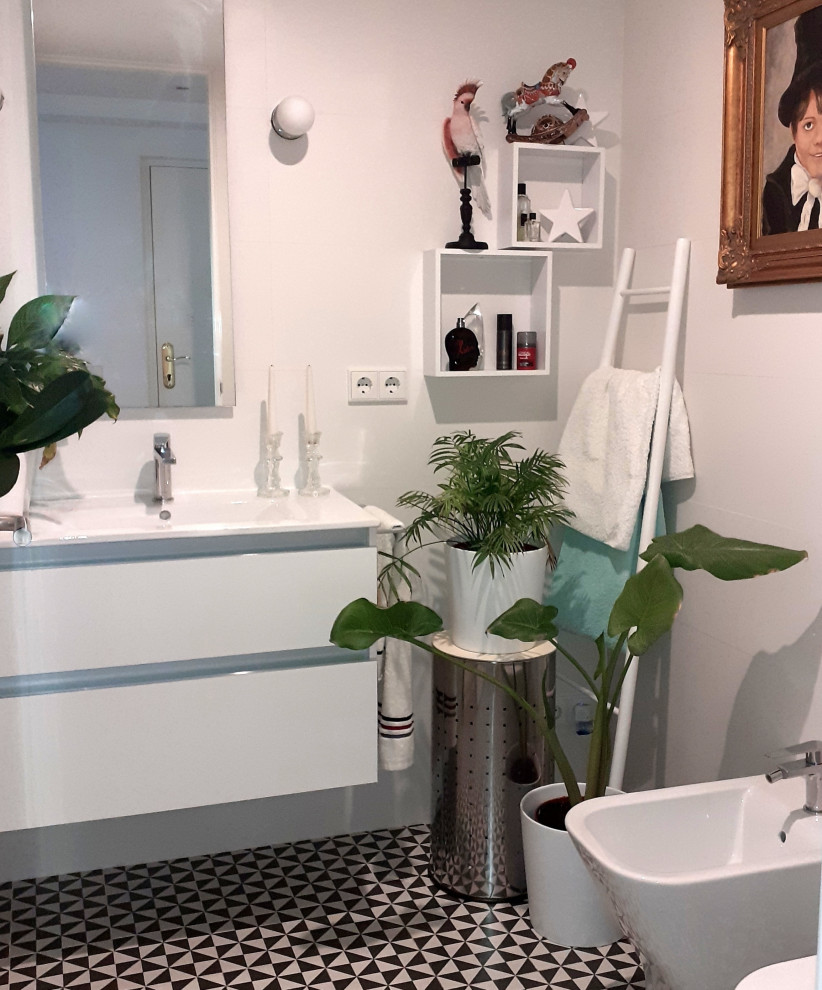 Exempel på ett litet medelhavsstil vit vitt badrum med dusch, med möbel-liknande, vita skåp, en kantlös dusch, en toalettstol med separat cisternkåpa, svart och vit kakel, keramikplattor, vita väggar, klinkergolv i keramik, ett integrerad handfat, kaklad bänkskiva, svart golv och dusch med gångjärnsdörr