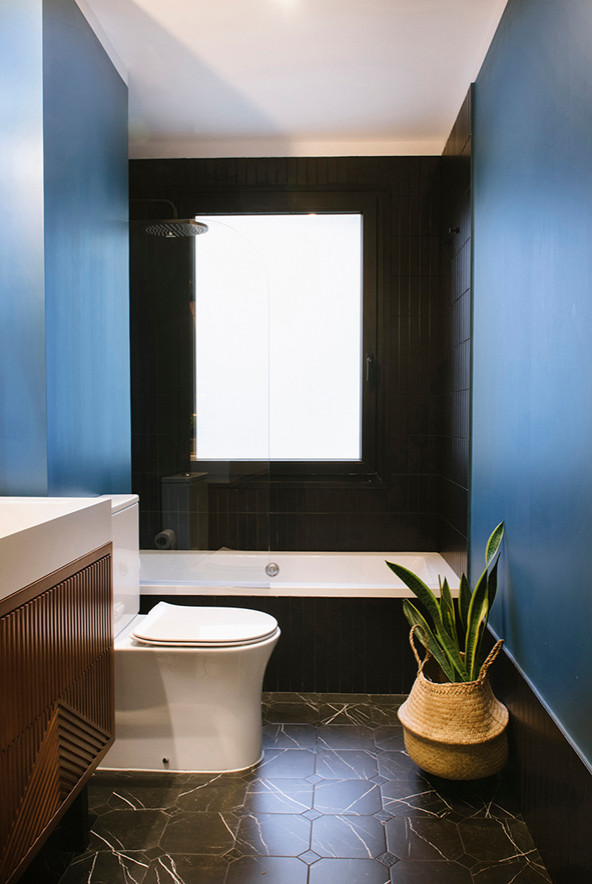 Idée de décoration pour une salle de bain principale tradition de taille moyenne avec un placard en trompe-l'oeil, des portes de placard blanches, une baignoire en alcôve, un combiné douche/baignoire, WC suspendus, un carrelage noir, des carreaux de porcelaine, un mur bleu, un sol en marbre, une vasque, un plan de toilette en quartz modifié, un sol noir et une cabine de douche à porte battante.