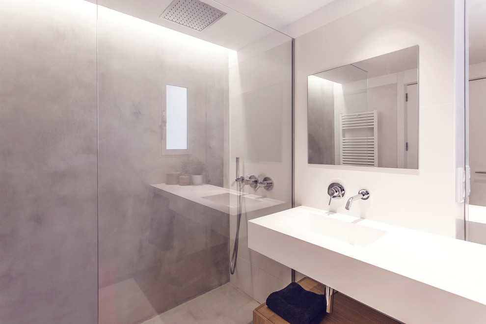 Imagen de cuarto de baño actual de tamaño medio con armarios abiertos, ducha a ras de suelo, paredes grises, aseo y ducha, lavabo integrado y microcemento