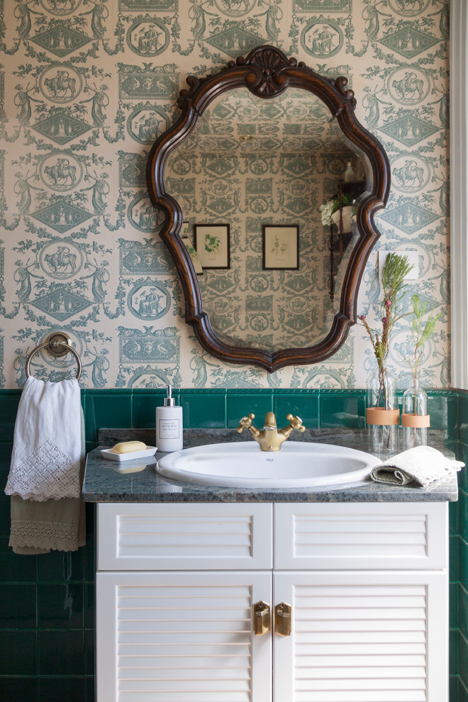 Réalisation d'une salle de bain design avec un placard à porte persienne, des portes de placard blanches, un carrelage vert, un mur vert, un lavabo posé et un plan de toilette gris.