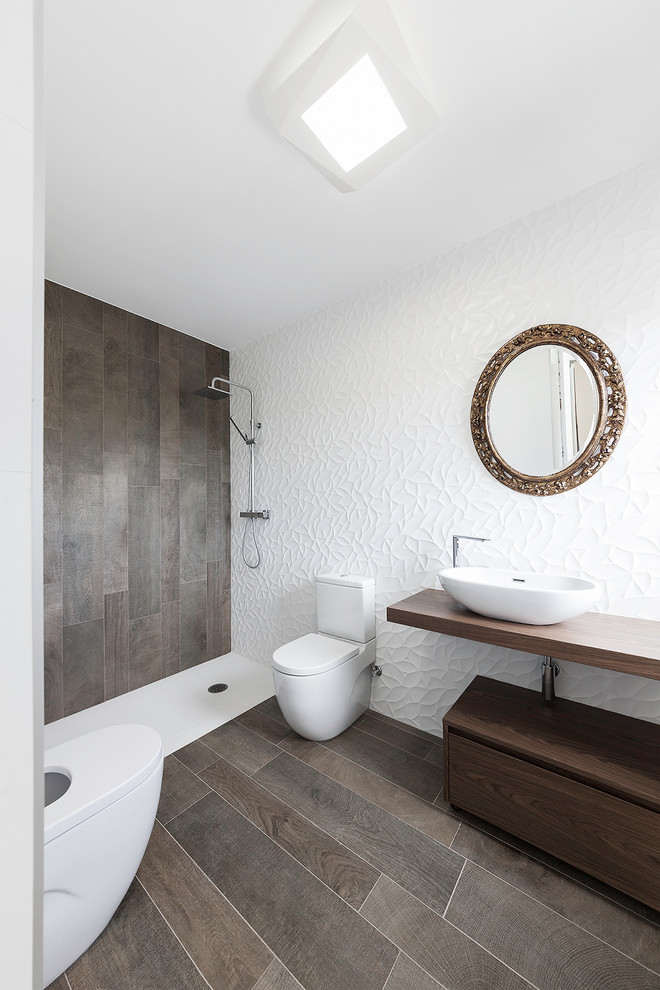 Photo of a contemporary shower room bathroom in Other with open cabinets, dark wood cabinets, a built-in shower, white tiles, white walls, porcelain flooring, a vessel sink, wooden worktops, brown floors and an open shower.
