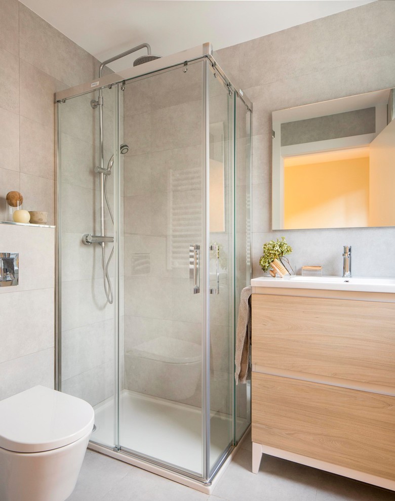Kleines Modernes Duschbad mit flächenbündigen Schrankfronten, beigen Schränken, Eckdusche, Toilette mit Aufsatzspülkasten, beiger Wandfarbe, integriertem Waschbecken und Falttür-Duschabtrennung in Bilbao