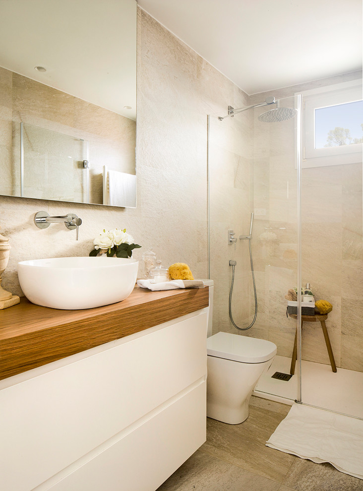 Inredning av ett medelhavsstil mellanstort badrum med dusch, med släta luckor, vita skåp, en kantlös dusch, en toalettstol med separat cisternkåpa och ett fristående handfat